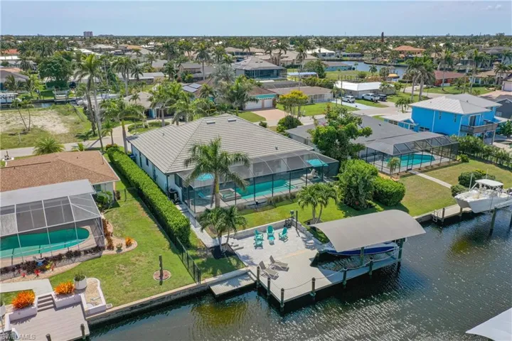Aerial perspective of suburban area featuring a nearby body of water and a pool