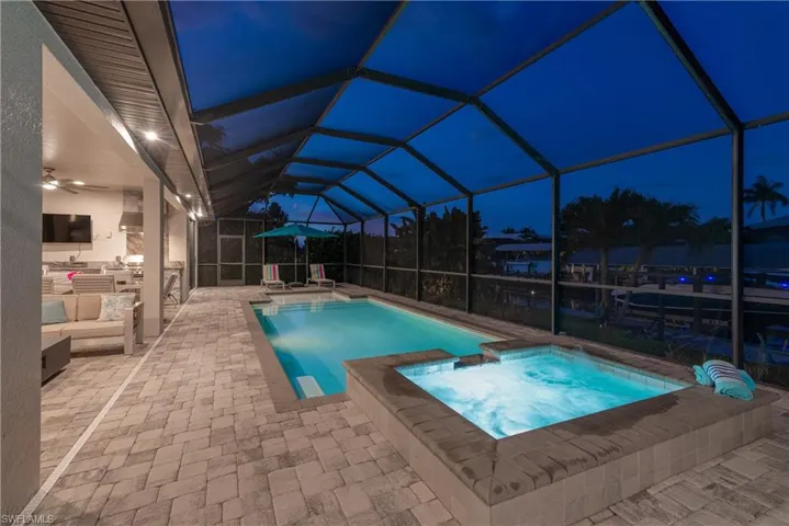 View of swimming pool with a patio, an outdoor living space, a lanai, and a pool with connected hot tub