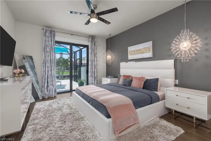 Bedroom featuring access to exterior, wood finished floors, a chandelier, and a ceiling fan