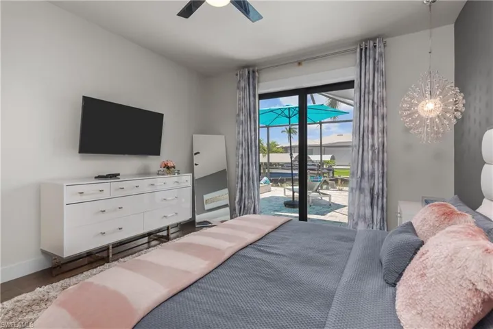 Bedroom with access to exterior, wood finished floors, baseboards, and ceiling fan