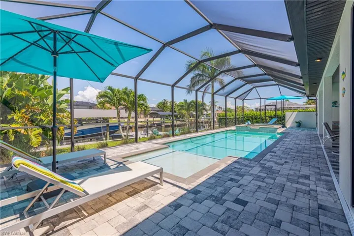 Swimming pool with a patio, a jacuzzi, and a lanai