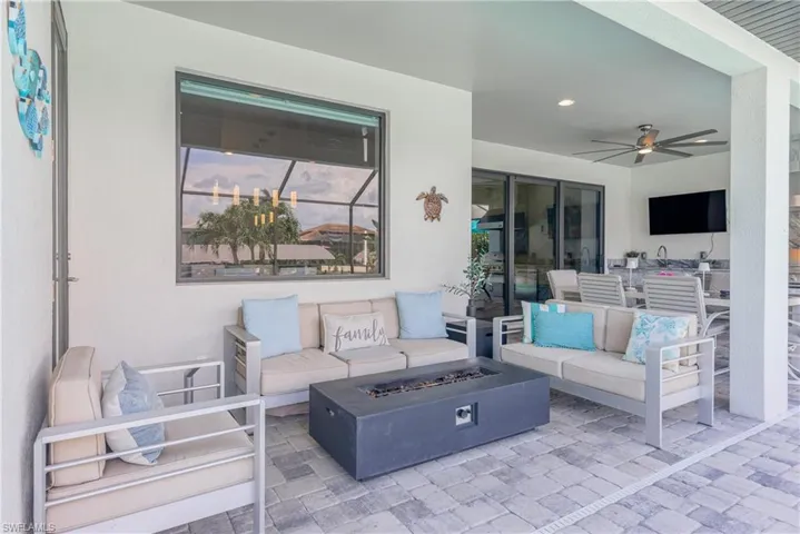 View of patio with an outdoor living space with a fire pit and a ceiling fan