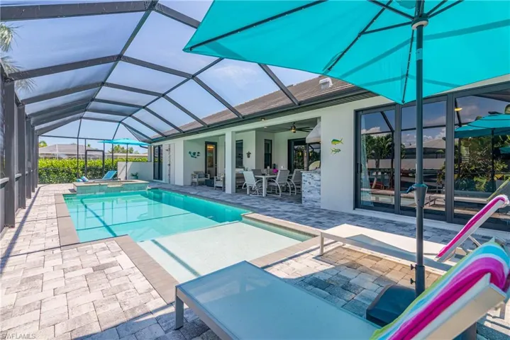 View of pool with a patio area, a ceiling fan, a lanai, and a pool with connected hot tub