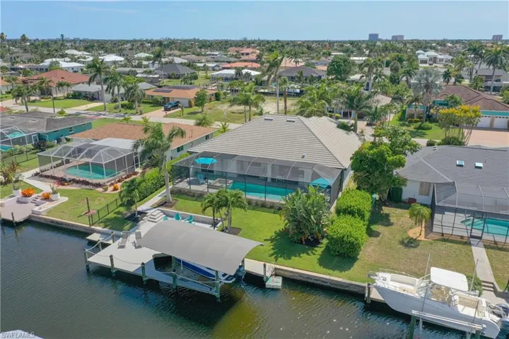 Aerial view of residential area with a nearby body of water and a pool area