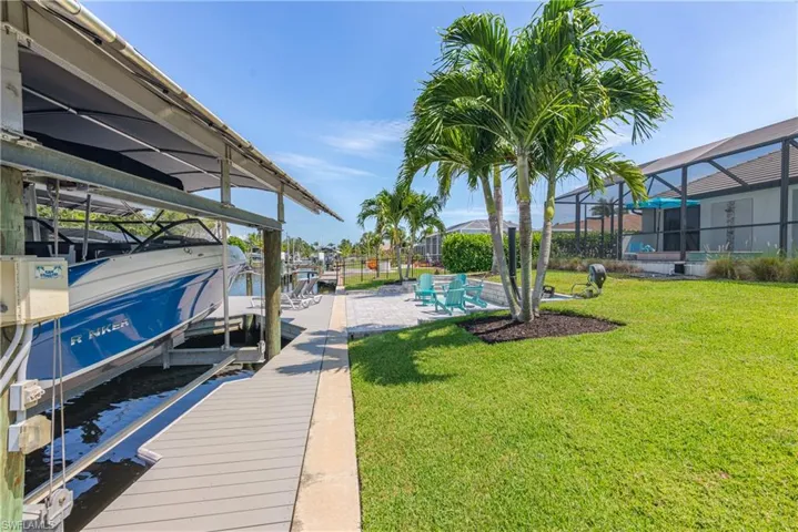 Dock featuring boat lift and a lawn