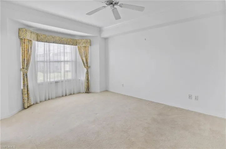 Carpeted spare room featuring crown molding and ceiling fan