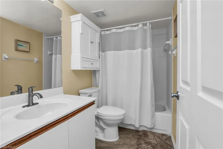 Bathroom featuring vanity, toilet, tile patterned flooring, and shower / bath combo