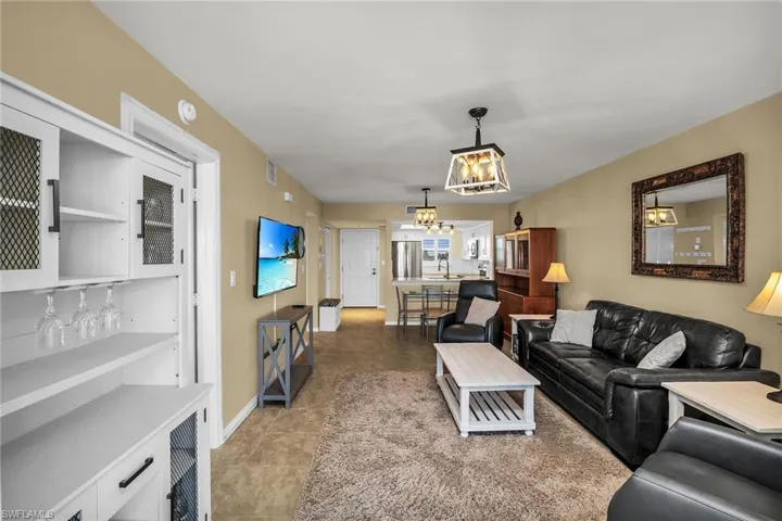 Living room with a chandelier, baseboards, and tile patterned flooring