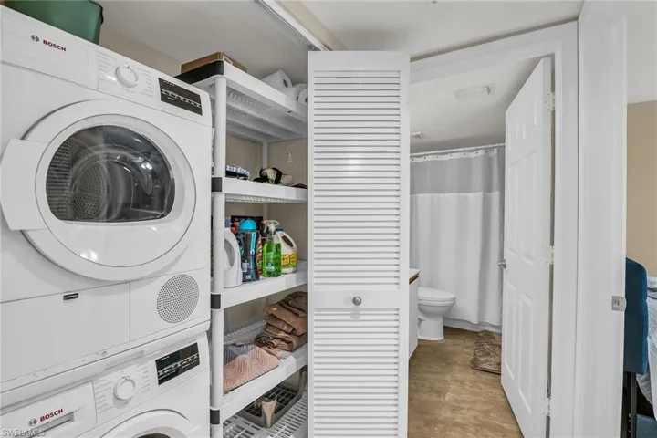Laundry area with stacked washer and clothes dryer