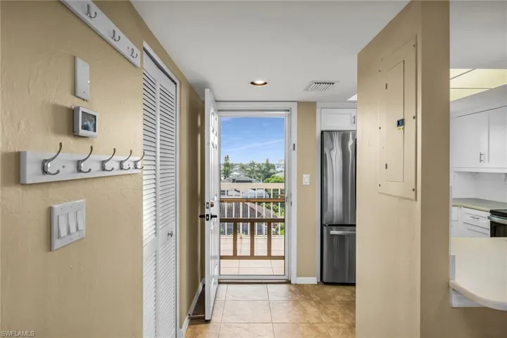 Doorway featuring baseboards and light tile patterned flooring