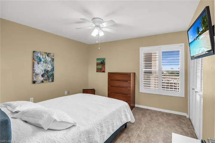 Bedroom featuring baseboards, a ceiling fan, and tile patterned flooring