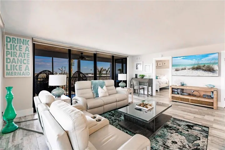 Living room with light hardwood / wood-style floors, a wall of windows, and ceiling fan