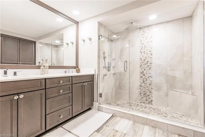Bathroom with vanity and a shower with door