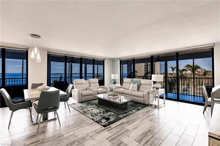 Living room featuring a water view, expansive windows, and ceiling fan
