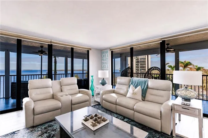 Living room featuring a water view, plenty of natural light, and a wall of windows
