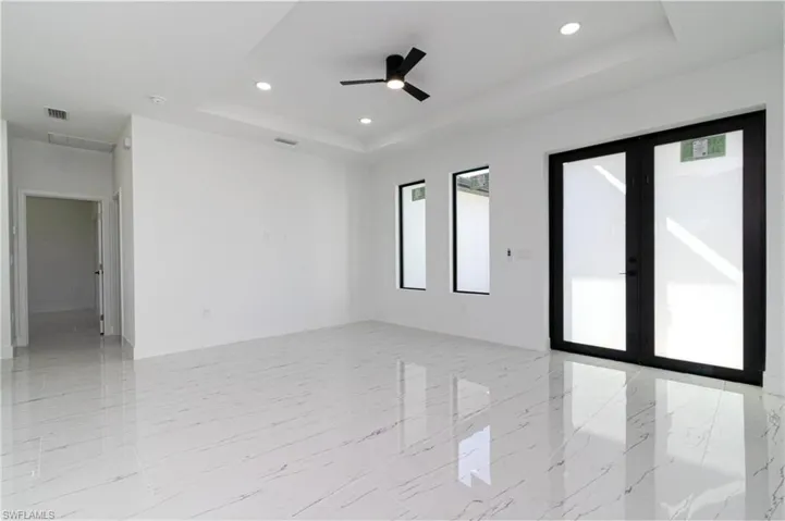 Spare room featuring a raised ceiling, french doors, marble finish floor, and visible vents