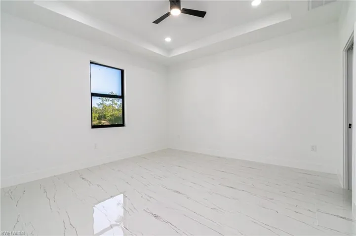 Spare room with recessed lighting, baseboards, a ceiling fan, and a raised ceiling