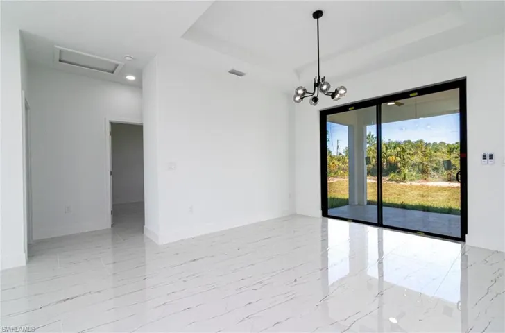 Empty room with baseboards, attic access, visible vents, a tray ceiling, and marble finish floor
