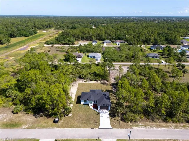 Birds eye view of property featuring a forest view and a residential view