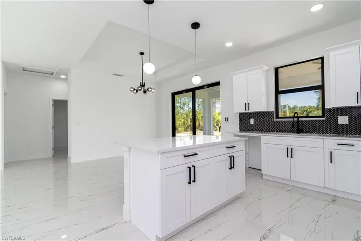 Kitchen featuring decorative backsplash, marble finish floor, a sink, and recessed lighting