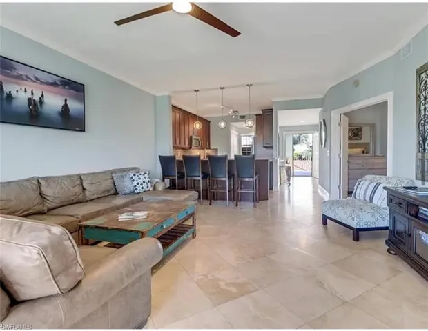 Living room featuring a ceiling fan, crown molding, and rail lighting