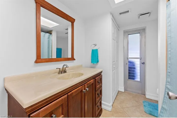 Full bath with a shower with curtain, vanity, and light tile patterned flooring