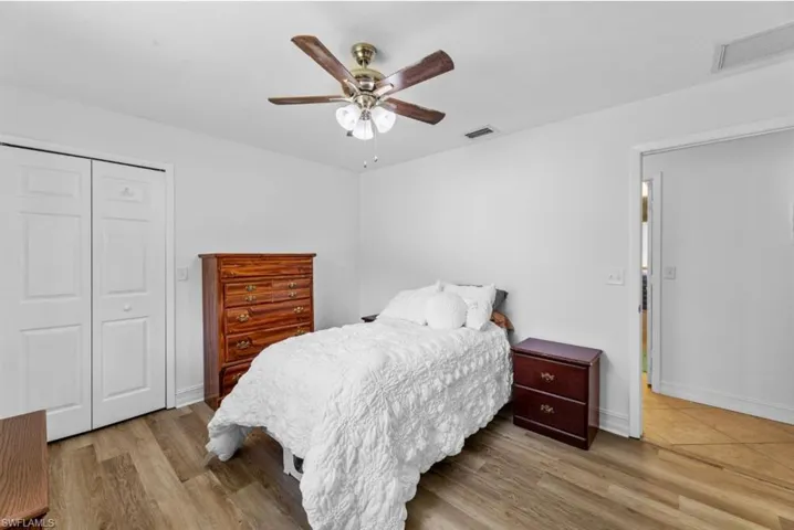 Bedroom featuring ceiling fan, a closet, and light wood-style floors