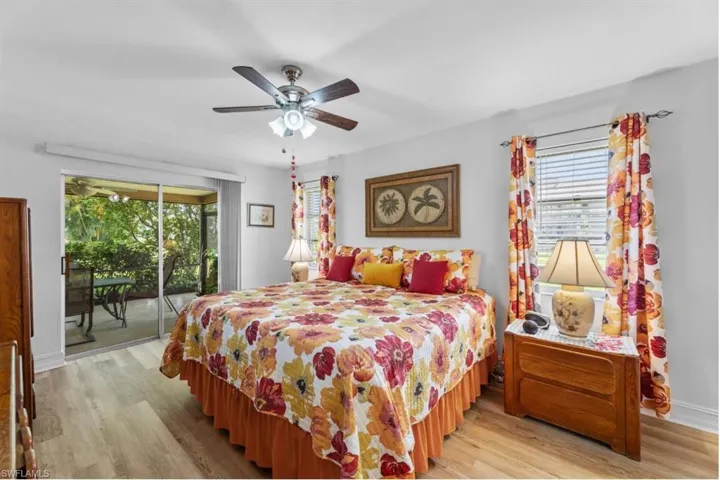 Bedroom featuring access to exterior, light wood-style floors, and ceiling fan