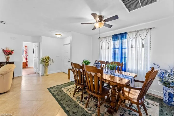 Dining space with ceiling fan and light tile patterned floors