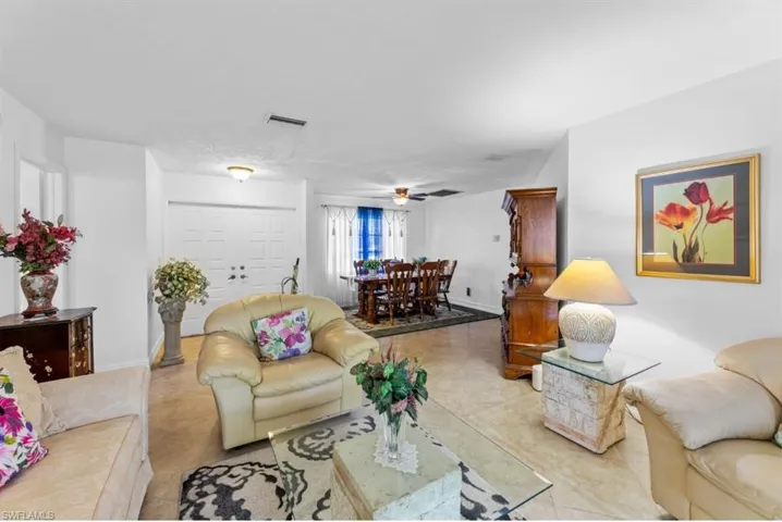 Living room featuring a ceiling fan and tile patterned flooring