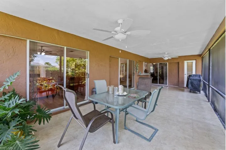 Sunroom / solarium with outdoor dining space and ceiling fan