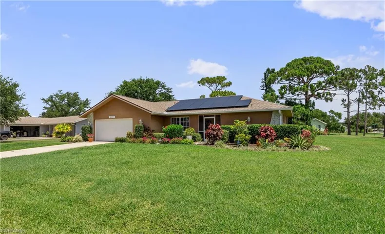 Single story home with a front lawn, concrete driveway, stucco siding, and a garage