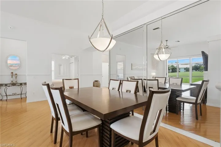 The formal dining room is enhanced by dramatic floor-to-ceiling mirrors that create a grand sense of space while beautifully reflecting the lush golf course views, adding depth, light, and timeless elegance.