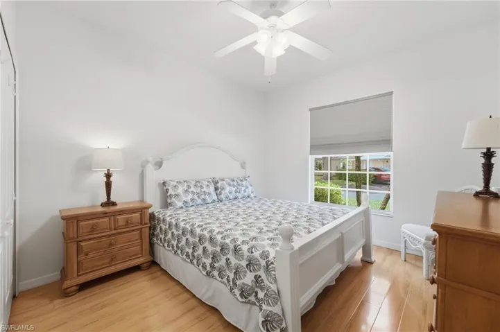 The inviting third bedroom features elegant Hunter Douglas shades, an abundance of natural light, and a comfortable retreat designed for guests, family, or flexible living needs.