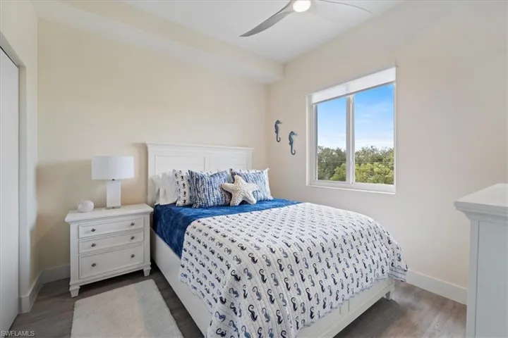 Bedroom featuring dark wood-style floors, a ceiling fan, and baseboards