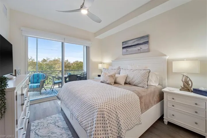 Bedroom with access to outside, a ceiling fan, and dark wood-style flooring