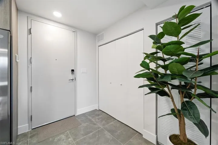 Foyer entrance with tile patterned floors, visible vents, and recessed lighting