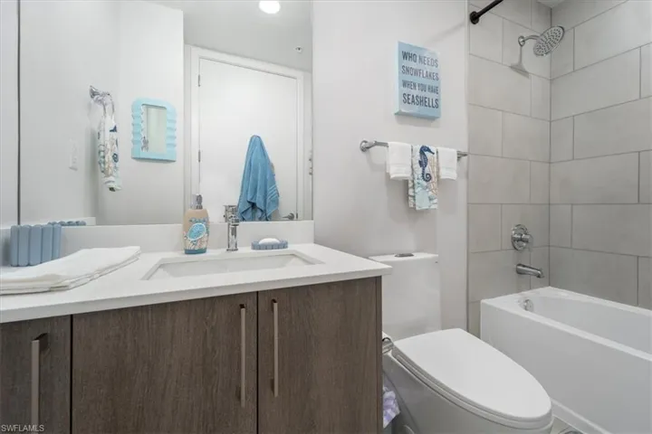 Bathroom with toilet, bathing tub / shower combination, and vanity