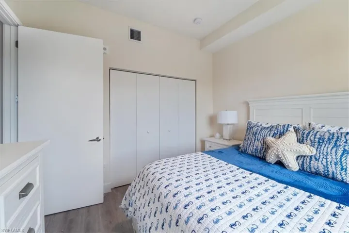 Bedroom with a closet, visible vents, and light wood finished floors