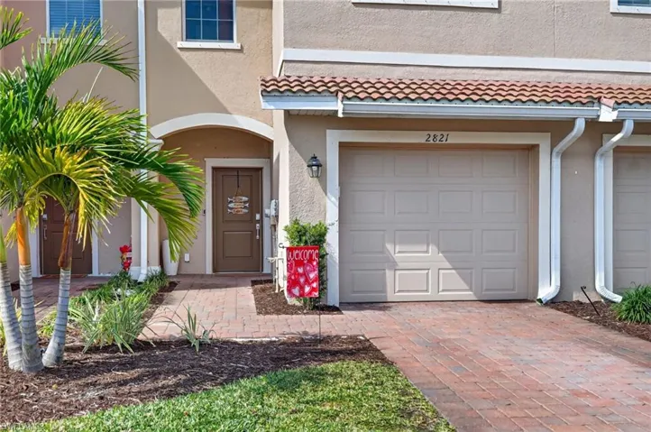 Property entrance featuring a garage, stucco siding, and driveway