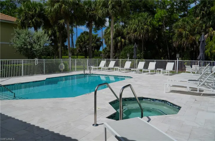 Community pool with a patio area and a community hot tub