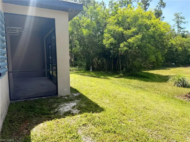 Screened patio with a concrete floor, stucco exterior, and a lush green lawn