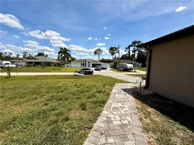 Exterior features include a paver walkway, stucco siding, and a dark shingle roof