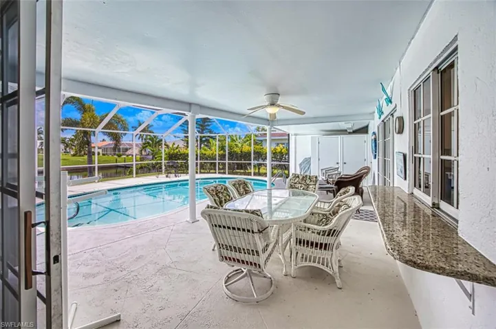 Outdoor pool featuring a sunroom, a patio area, a lanai, and outdoor dining space