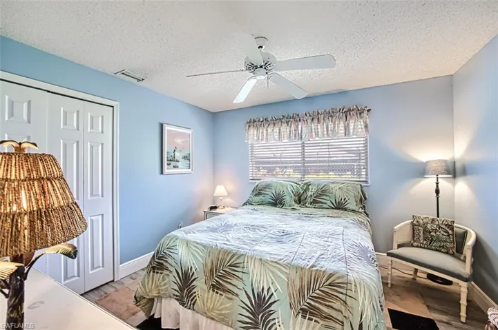 Bedroom featuring a closet, ceiling fan, a textured ceiling, and wood finished floors