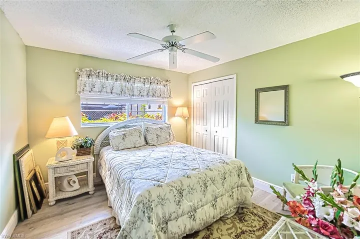 Bedroom featuring wood finished floors, a closet, a ceiling fan, and a textured ceiling