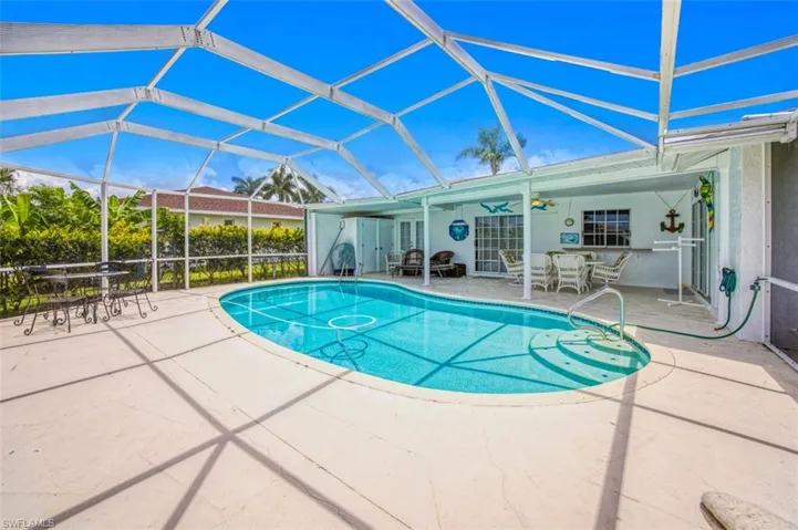 Swimming pool with outdoor dining area, a sunroom, a patio area, and glass enclosure
