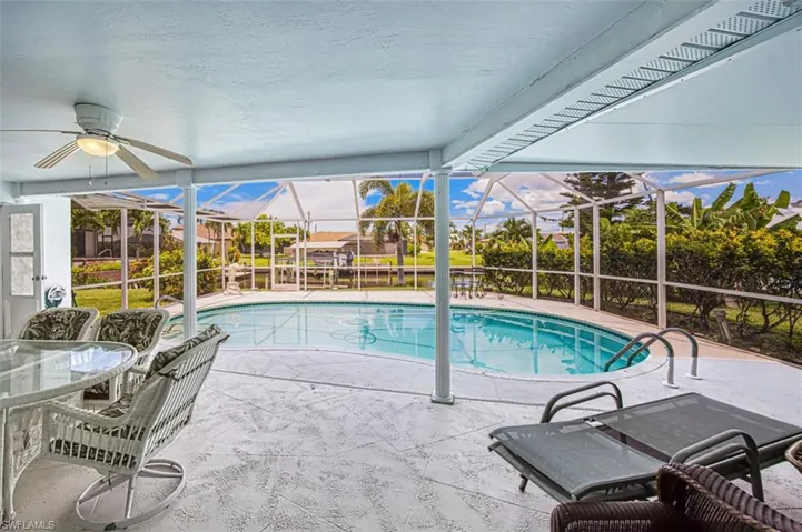 Outdoor pool featuring glass enclosure, a patio area, a sunroom, and outdoor dining area