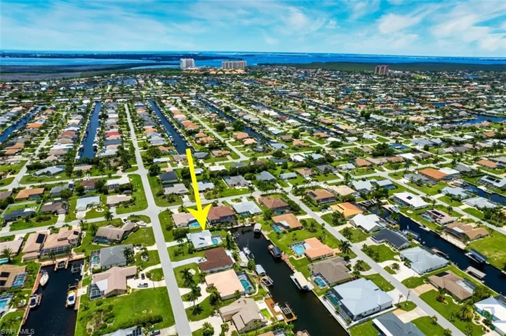 Aerial perspective of suburban area featuring a nearby body of water