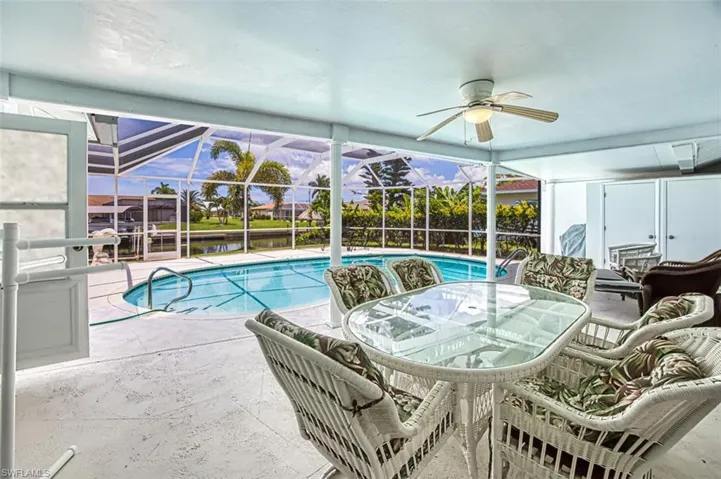 Swimming pool featuring a lanai, outdoor dining area, a patio area, and a sunroom
